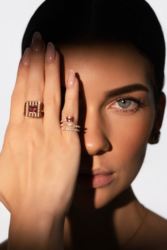 Woman wearing rings on her hand with a plain background